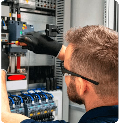 Electrician working inside an electrical cabinet